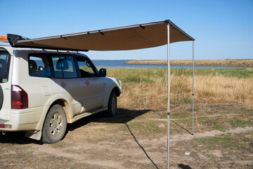 Side Awning setup to provide shade during summer, when camping, © P.j.Hickox