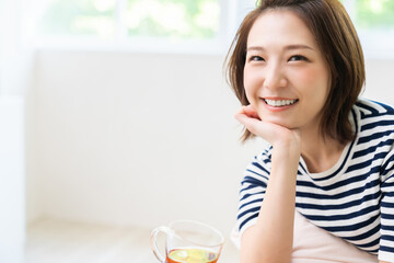 部屋でリラックスする若い女性　飲み物