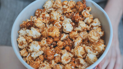 Girl eating popcorn on the street. Close-up of hands.