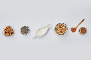 different types of cereals in bowls and spoons on a white background with copy space to the top right