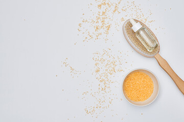 gold flakes on a white surface with a spoon full of flakes next to it and scattered flakes