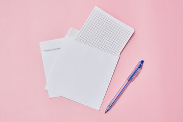 an open notebook, pen and paper on a pink background with copy - up sheets in the top right corner