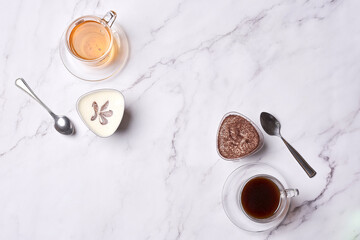 two cups of tea and spoons on a marble table with white marble countertops in the photo is taken from above