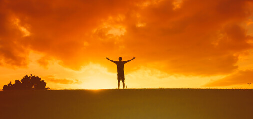 Man with arms outstretched to the sky with feelings of happiness, freedom, and hope 