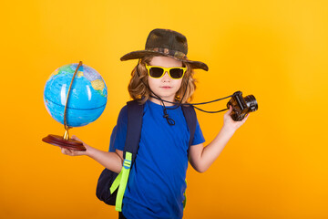 Travel and adventure concept. Little child boy tourist explorer with globe world. Discovery, exploring and education. Studio isolated portrait.