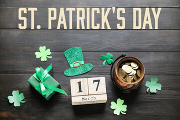 Leprechaun's pot with golden coins, gift and calendar with date of St. Patrick's Day on dark wooden...