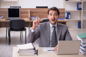 Young male employee unhappy with excessive work in the office