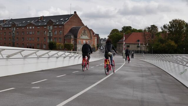 People ride bicycle and walk on pedestrian and bicycle bridge Lille Langebro,
Little Long Bridge link Langebrogade on the Christianshavn side to Christians Brygge.
