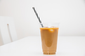 Ice coffeee with milk and ice cubes on white table