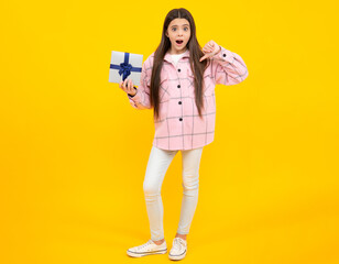 Emotional teenager child hold gift on birthday. Funny kid girl holding gift boxes celebrating happy New Year or Christmas. Angry teenager girl, upset and unhappy negative emotion.