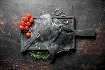 Fresh raw fish on a wooden chopping Board with rosemary.