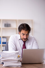 Young male employee and too much work in the office