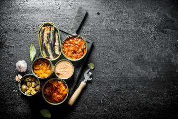 Open tin cans of canned food on the cutting Board.