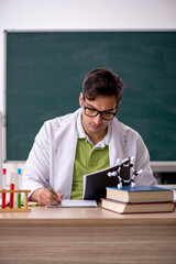 Young male chemist in the classroom