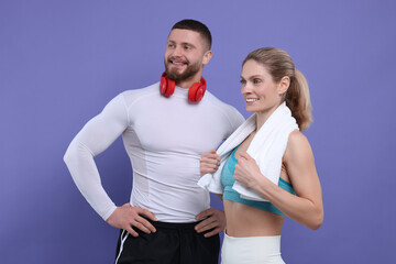 Athletic people with headphones and towel on purple background