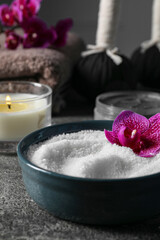 Obraz na płótnie Canvas Beautiful composition with sea salt, burning candle, flowers and different spa products on grey table, closeup