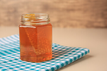 Jar with honey and combs on light table, space for text