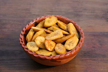 Tasty deep fried banana slices on wooden table