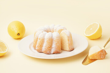 Plate with delicious cake and lemons on yellow background