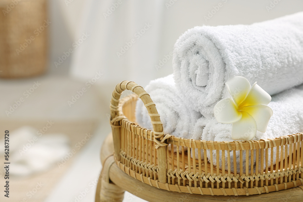 Wall mural rolled towels on wicker table in bathroom, closeup. space for text