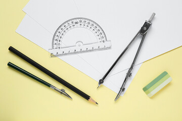 Different rulers and compass on yellow background, flat lay
