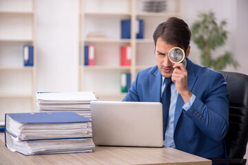 Young male employee and too much work in the office