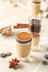Shots of delicious pudding with cinnamon, anise and chocolate on tile table