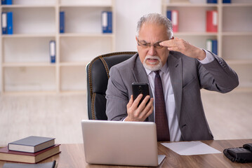 Old male employee working in the office