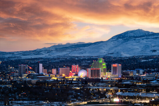 Reno, Nevada city skyline at sunset during winter with snowy mountains in the background