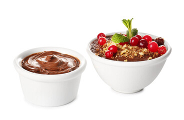 Bowls of delicious chocolate pudding with cranberry and mint isolated on white background