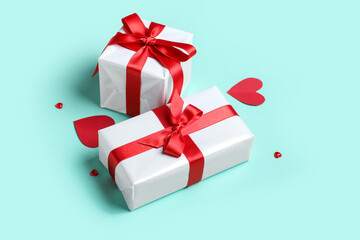 Gift boxes with beautiful bows on mint background. Valentine's Day celebration