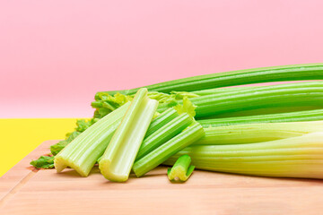 Fresh Celery Stem and Chopped Celery Sticks on Wooden Cutting Board. Vegan and Vegetarian Culture. Raw Food. Healthy Diet with Negative Calorie Content. Slimming Food