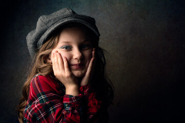 Portrait of a cute little girl touching her face with the hands