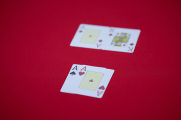 player shows two play card aces on a red table in a casino. gambling