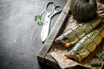 Smoked mackerel on a wooden tray with old twine.