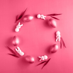 Fototapeta na wymiar Creative Easter wreath made from wooden eggs, marshmallow bunny and grass on viva magenta trend 2023 color background. Spring, easter monochrome concept. Flat lay, top view, copy space, square