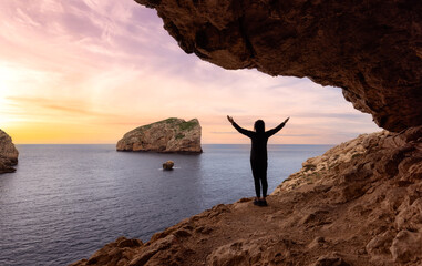 Adventurous Woman in a Cave on Rocky Coast with Cliffs on the Mediterranean Sea. Regional Natural Park of Porto Conte, Sardinia, Italy. Adventure Travel. Sunset Sky Art Render.