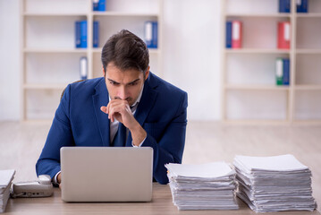 Young male employee and too much work in the office