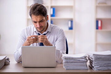 Young male employee and too much work in the office