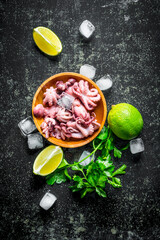 Baby octopus on a plate with slices of lime, ice and parsley.