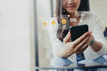 Customer satisfaction concept, Young woman using smartphone check mark icon face emoticon smiling for evaluate product and service.