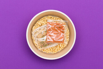 Opened Package with Uncooked Instant Noodles on Violet Background. Raw Pasta. Dry Asian Fast Food. Quick Lunch