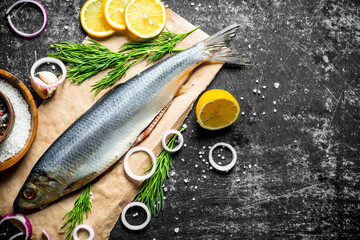 Delicious salted herring with slices of lemon, onion and herbs.