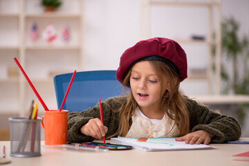Young little girl enjoying painting at home