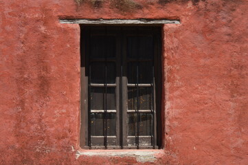 Ventana antigua en pared rojiza, Colonia del Sacramento Uruguay