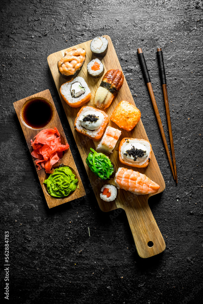 Poster Variants of types of sushi, rolls and maki on a cutting Board with sticks.