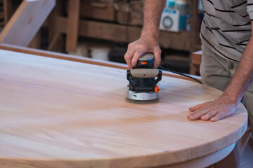 Male carpenter, working in the carpenter's workshop with power hand tools.