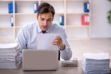 Young male employee and too much work in the office