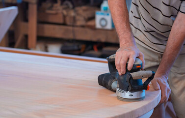 Male carpenter, working in the carpenter's workshop with power hand tools.