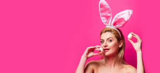 Sexy rabbit woman with eggs, isolated on pink banner, copy space. Wide photo banner for website header design.